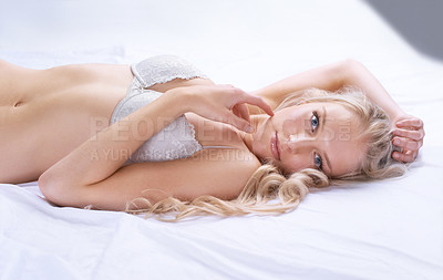 Buy stock photo Portrait, lingerie and young woman in lace bra or lying on a bed and touching her face with gentle hand on skin. Beautiful, sexy and model or bikini for cosmetic or underwear and body in bedroom