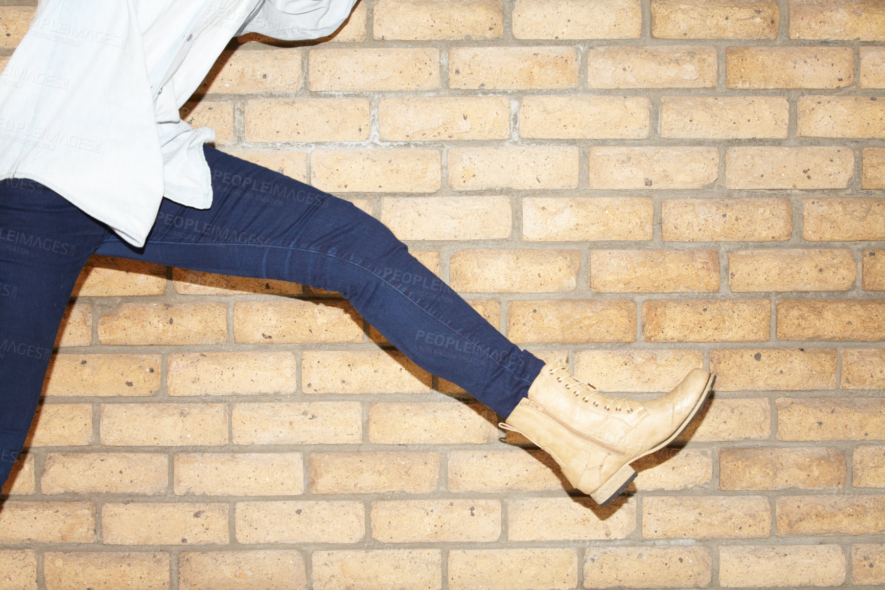 Buy stock photo Shoes, leg and closeup of woman at brick wall for casual, trendy jeans and stylish outfit. Boots, feet and zoom of person with elegant footwear for cool or edgy style, fashion or jump in urban city.
