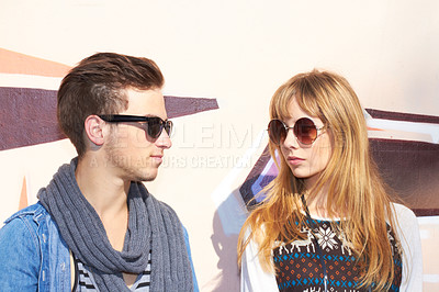 Buy stock photo A young and stylish couple standing outside wearing sunglasses