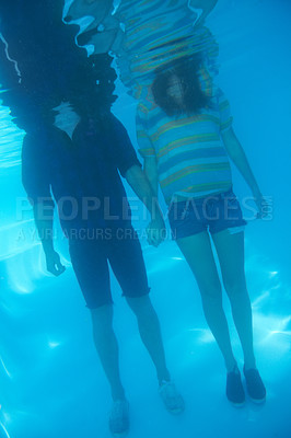 Buy stock photo Holding hands, swimming and a couple underwater for love, support or trust in relationship. Body, standing and a man and woman with care, affection and in a pool together for emotion or unity