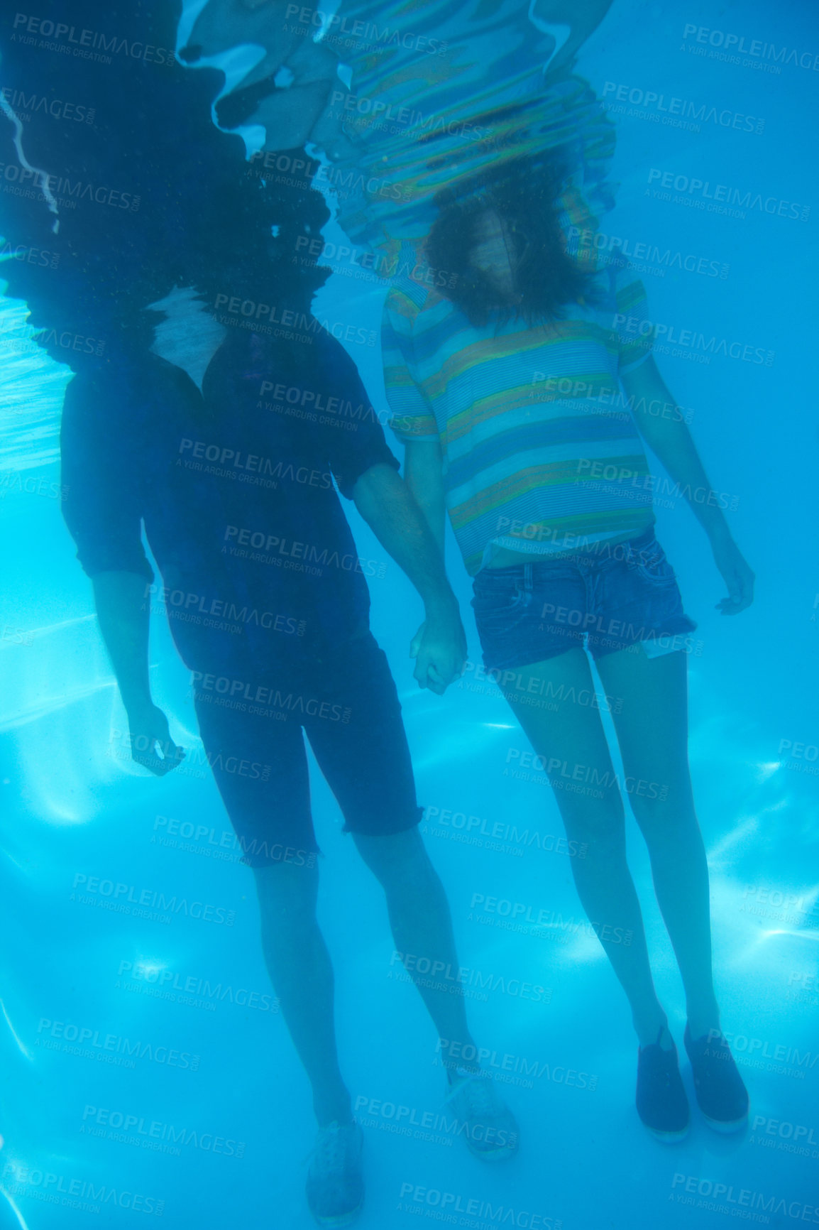 Buy stock photo Holding hands, swimming and a couple underwater for love, support or trust in relationship. Body, standing and a man and woman with care, affection and in a pool together for emotion or unity