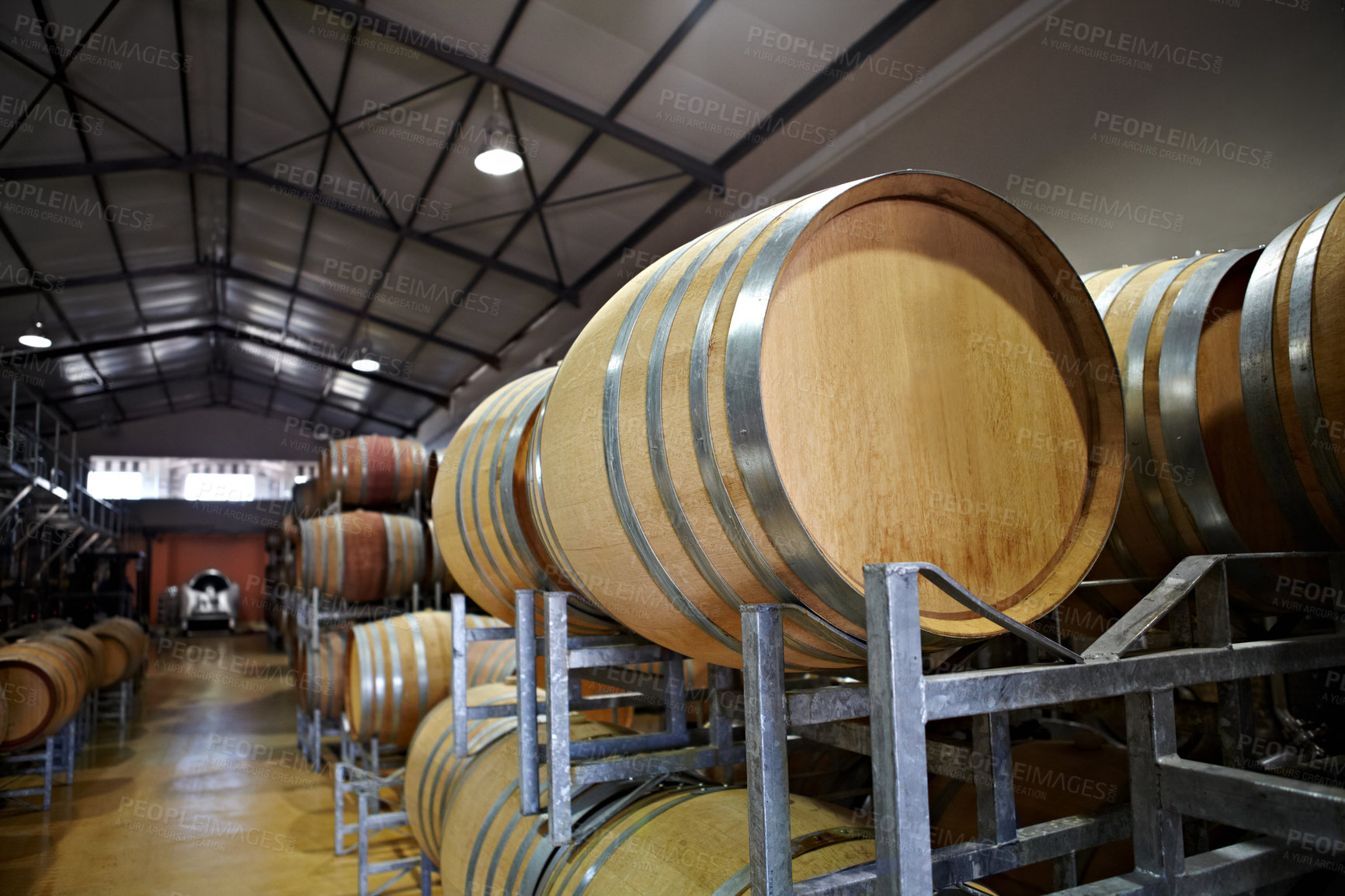 Buy stock photo Wine barrels in a warehouse distillery on a farm. Craft liquor at an alcohol brewery. Whisky and brandy cellar filled with fermenting aging drinks. Manufacturer in the process of producing spirits