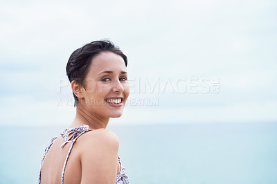 Buy stock photo An over the shoulder portrait of an attractive young woman enjoying a day out near the ocean