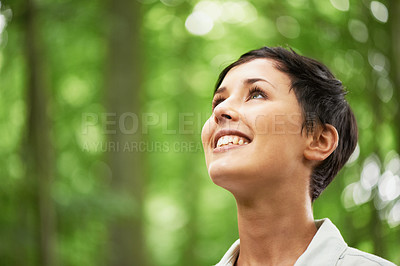 Buy stock photo A closeup shot of an attractive young woman looking upwards into the canopy of a forest