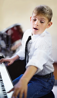 Buy stock photo Child, piano and music as pianist, fun and confidence with attention, musician and enjoy. Talent, creativity and passion with maestro, play and serious for musical, boy and practice concentration

