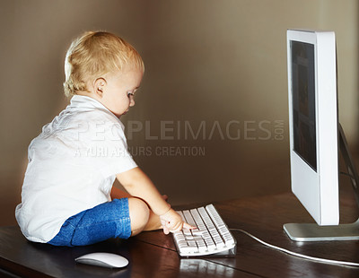 Buy stock photo Little cute baby boy sitting by the screen of a computer in a room at home. Curious baby boy browsing using a desktop pc all alone and typing on the keyboard