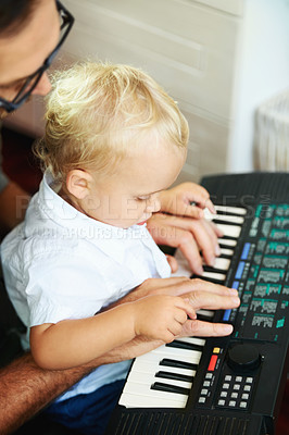 Buy stock photo Cute little boy being taught how to play the piano