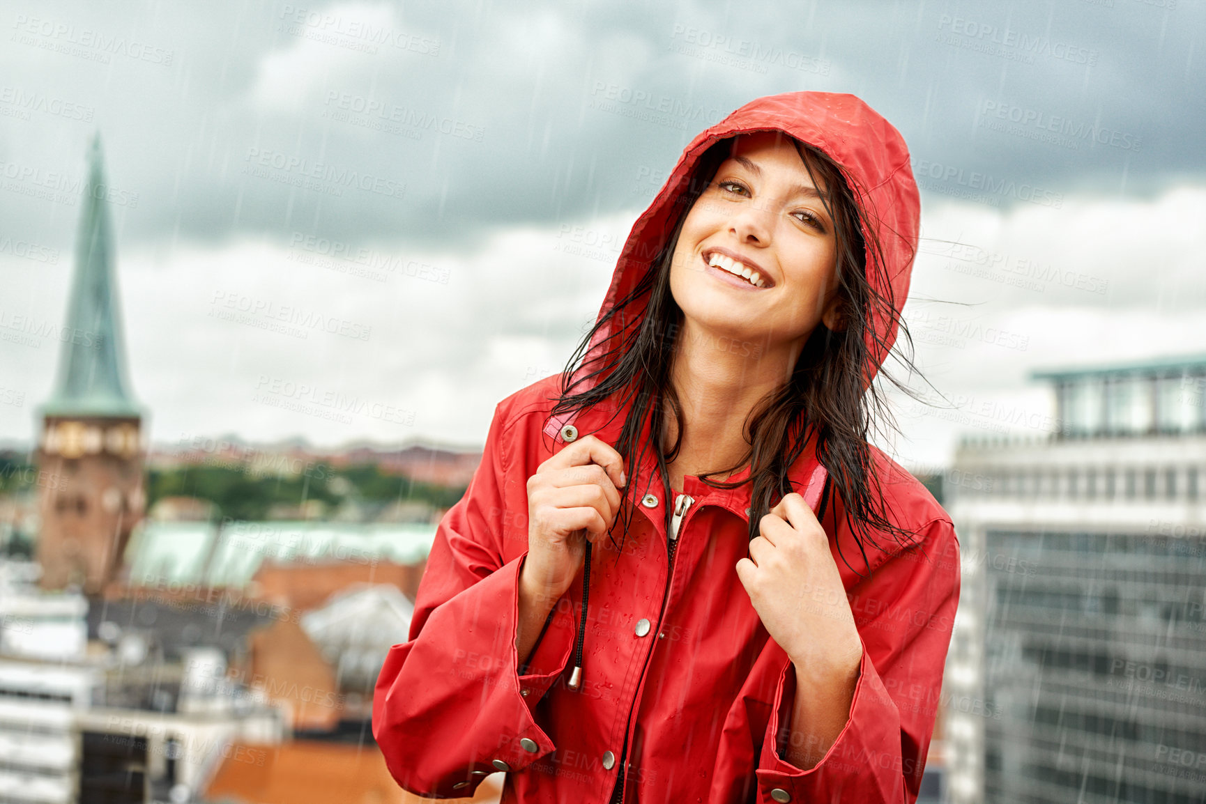 Buy stock photo Pretty young woman smiling while wearing a red raincoat - portrait