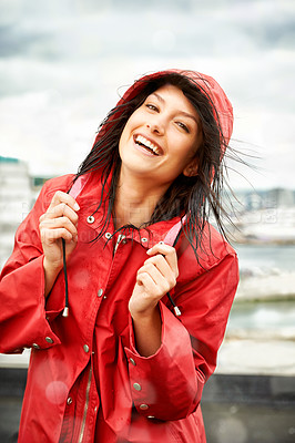 Buy stock photo Woman, smile and raincoat in portrait outdoors, storm and cold on holiday, travel and weather. Female person, happy and winter on vacation, outside and positive on rooftop, rainfall and insurance