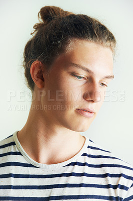 Buy stock photo Young, man and thinking with face in studio for looking, idea or vision on white background in London. Male model, pose and hairstyle with bun, different and indie for clothes, fashion and trendy