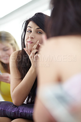 Buy stock photo Attractive young woman picking at her skin in front of a mirror