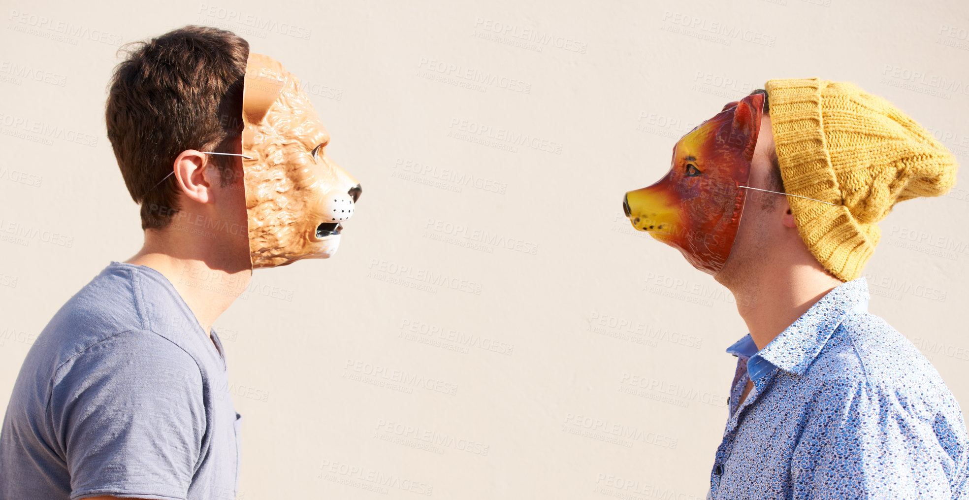 Buy stock photo Two young hipsters facing off while wearing animal masks
