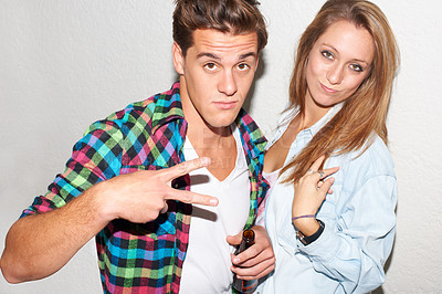 Buy stock photo Portrait of couple at party, peace sign and beer, gen z fashion and university drinking culture in youth. Happiness, woman and man at fun college event with drinks and smile on white wall background.