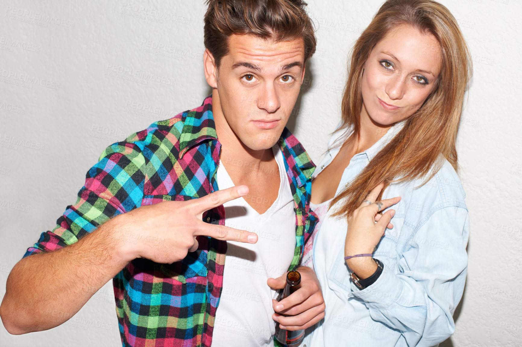 Buy stock photo Portrait of couple at party, peace sign and beer, gen z fashion and university drinking culture in youth. Happiness, woman and man at fun college event with drinks and smile on white wall background.