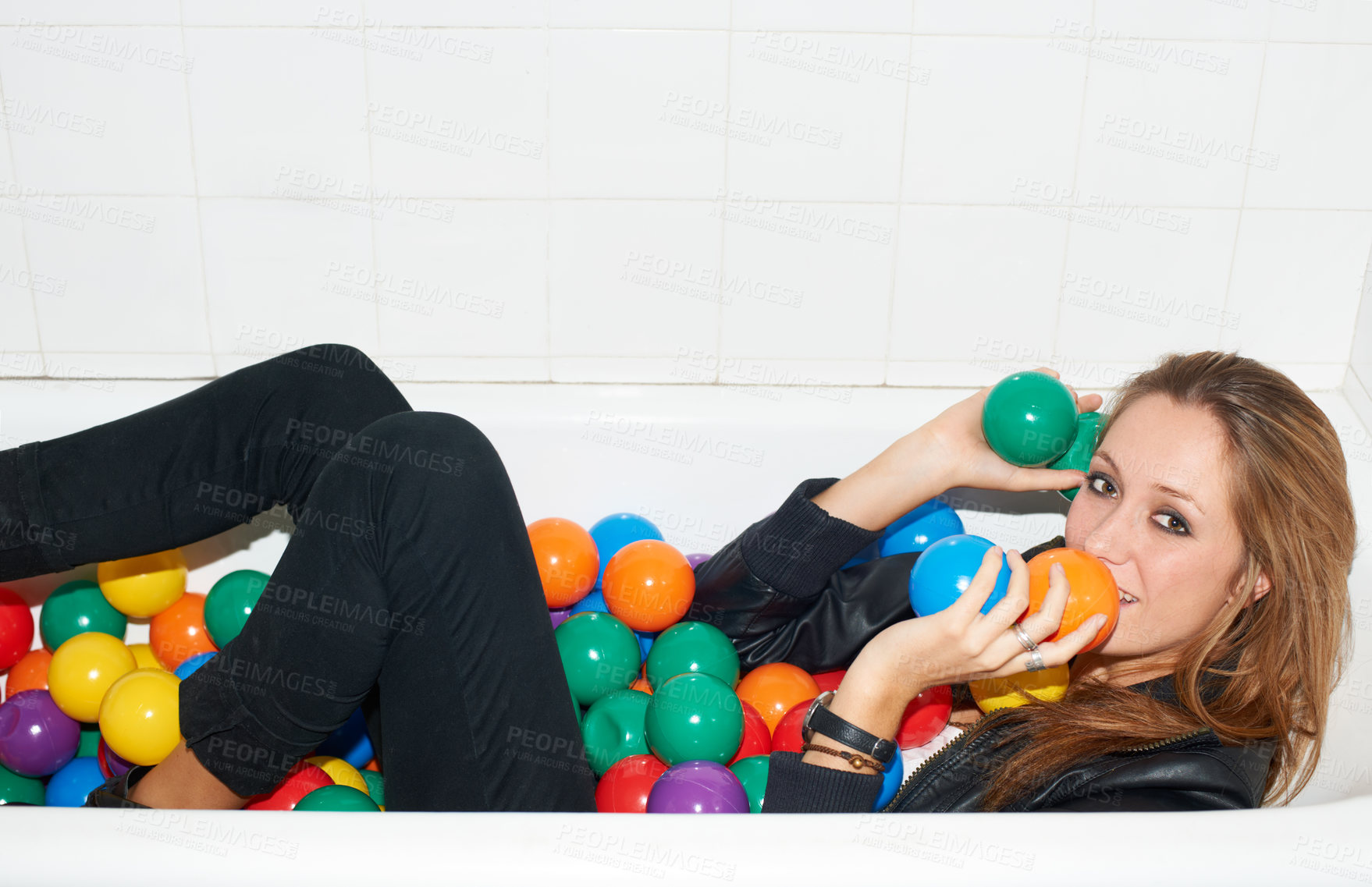 Buy stock photo Portrait, balls and woman in bathtub for fashion, style and trendy hipster at home. Happy person in tub with color, party or plastic with body in bathroom, relax in edgy and cool clothes in Canada