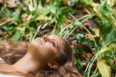 Buy stock photo A beautiful young woman lying on the forest floor