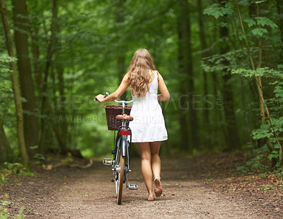 Buy stock photo Back, bike and a woman walking in the forest for travel, freedom or adventure in nature during spring. Sustainability, relax and a person pushing her bicycle in the countryside for peace or quiet