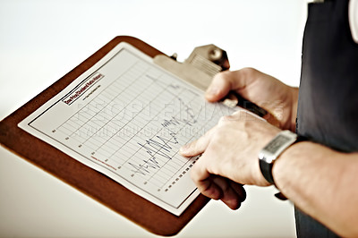 Buy stock photo A person pointing at a graph on a clipboard