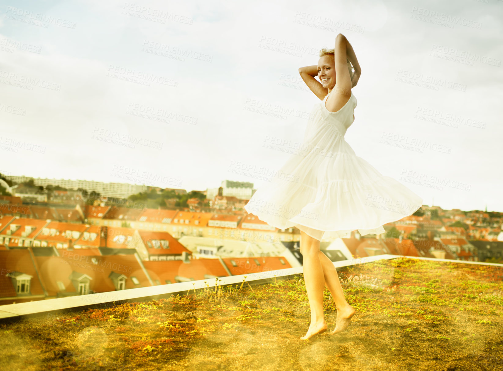 Buy stock photo Gorgeous young woman dancing on a rooftop surrounded by bokeh