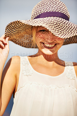 Buy stock photo A gorgeous young woman wearing a straw hat in the summer sun