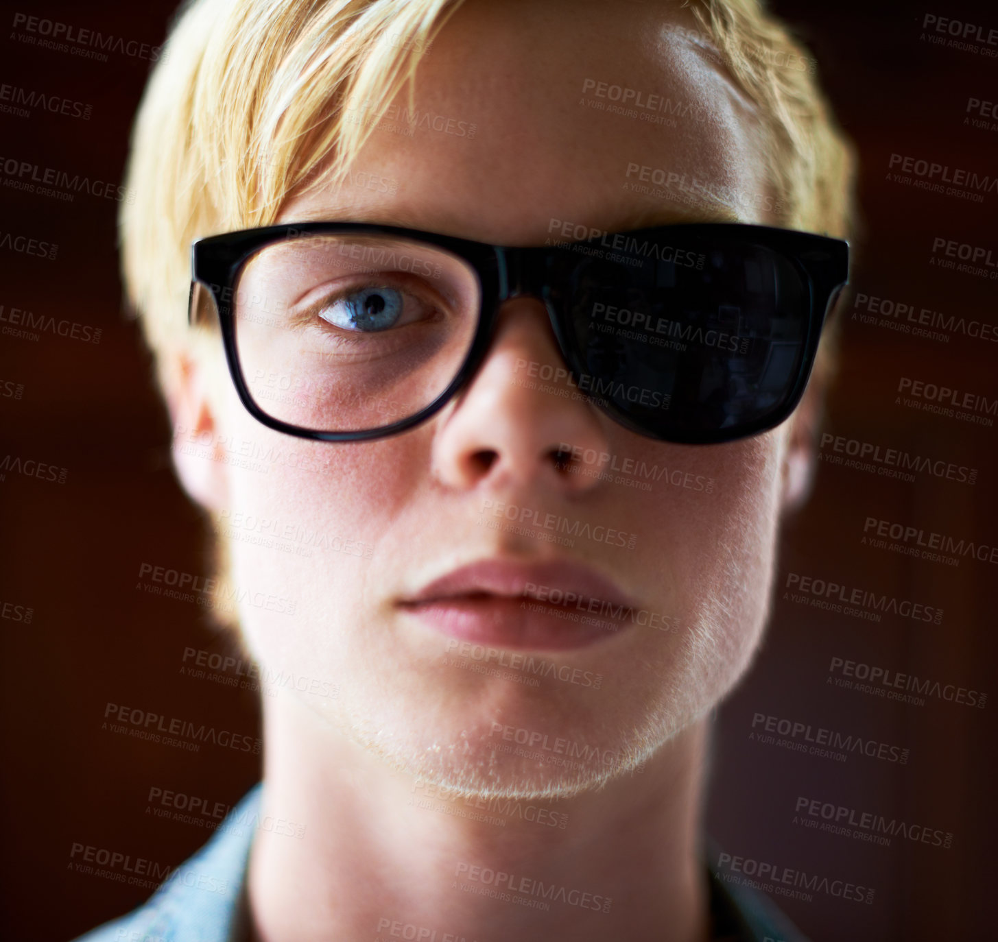 Buy stock photo Student, man and broken sunglasses for fashion isolated on brown background in studio. Portrait, glasses and serious, young and blonde person with shades for vision, style or cool face in Switzerland