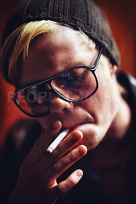 Buy stock photo Face, addiction and a boy smoking a cigarette closeup for nicotine or tobacco dependency in sunglasses. Style, smoke and bad habit with a young person inhaling an addictive substance for cancer