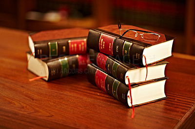 Buy stock photo Legal books, glasses and lawyer research textbook in a student library with no people. Justice, knowledge and judge book for investigation and attorney work in archive and university law department