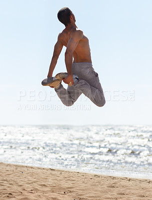 Buy stock photo An athletic young man practicing parkour on the beach
