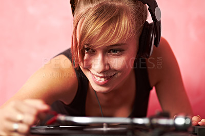 Buy stock photo Closeup of a young female dj putting a record on the turntable