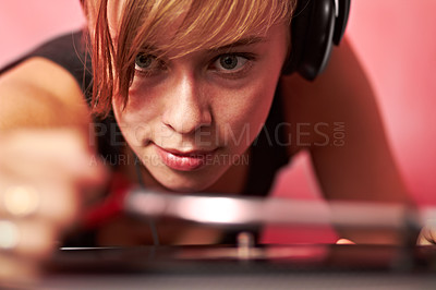 Buy stock photo DJ, music and concert with a woman in headphones on a pink background to play an audio record. Party, festival and sound with a female performer playing a psychedelic vinyl at a dance or disco