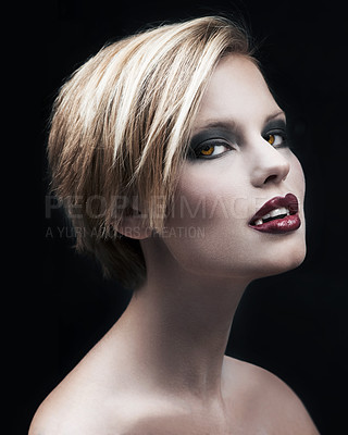 Buy stock photo A seductive female vampire with blood red lips against a dark background