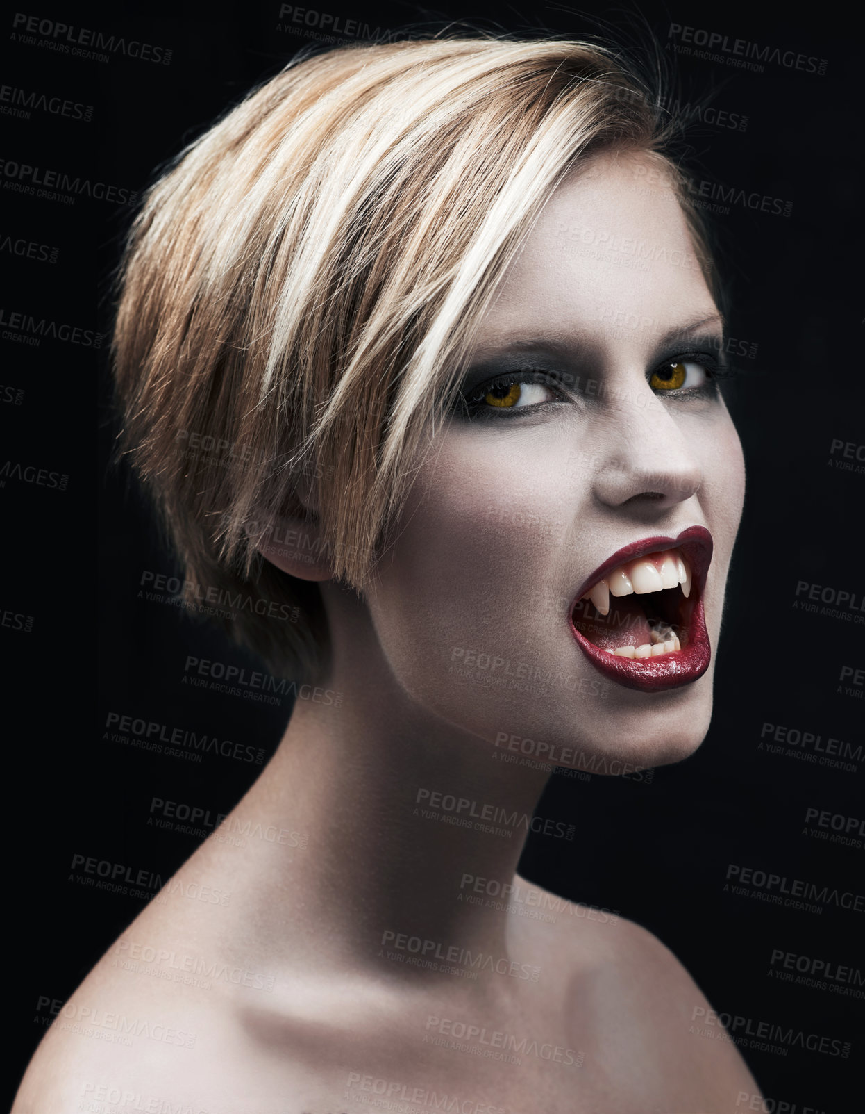 Buy stock photo Portrait, fangs and a woman vampire in studio on a dark background for halloween or cosplay. Fantasy, horror and scary with an attractive young monster posing as an evil or supernatural creature