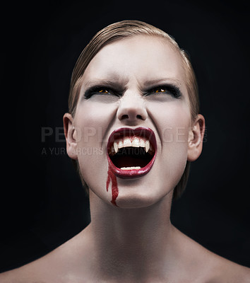 Buy stock photo A provocative female vampire with blood running down her chin