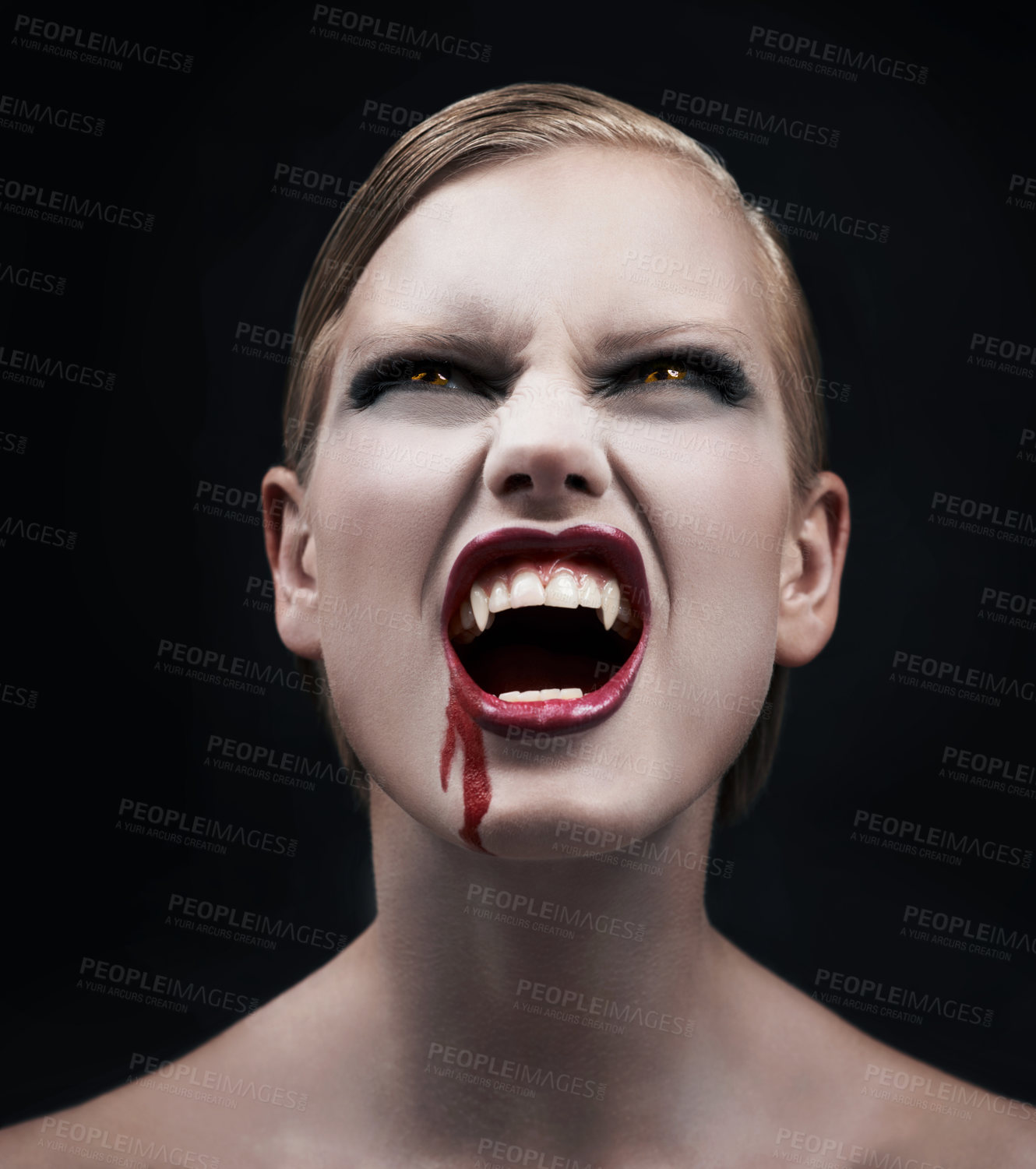 Buy stock photo A provocative female vampire with blood running down her chin