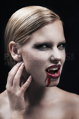 Buy stock photo Portrait, blood and a female vampire in studio on a dark background for halloween or cosplay. Fantasy, horror or scary with an attractive young woman monster posing as an evil and feminine creature