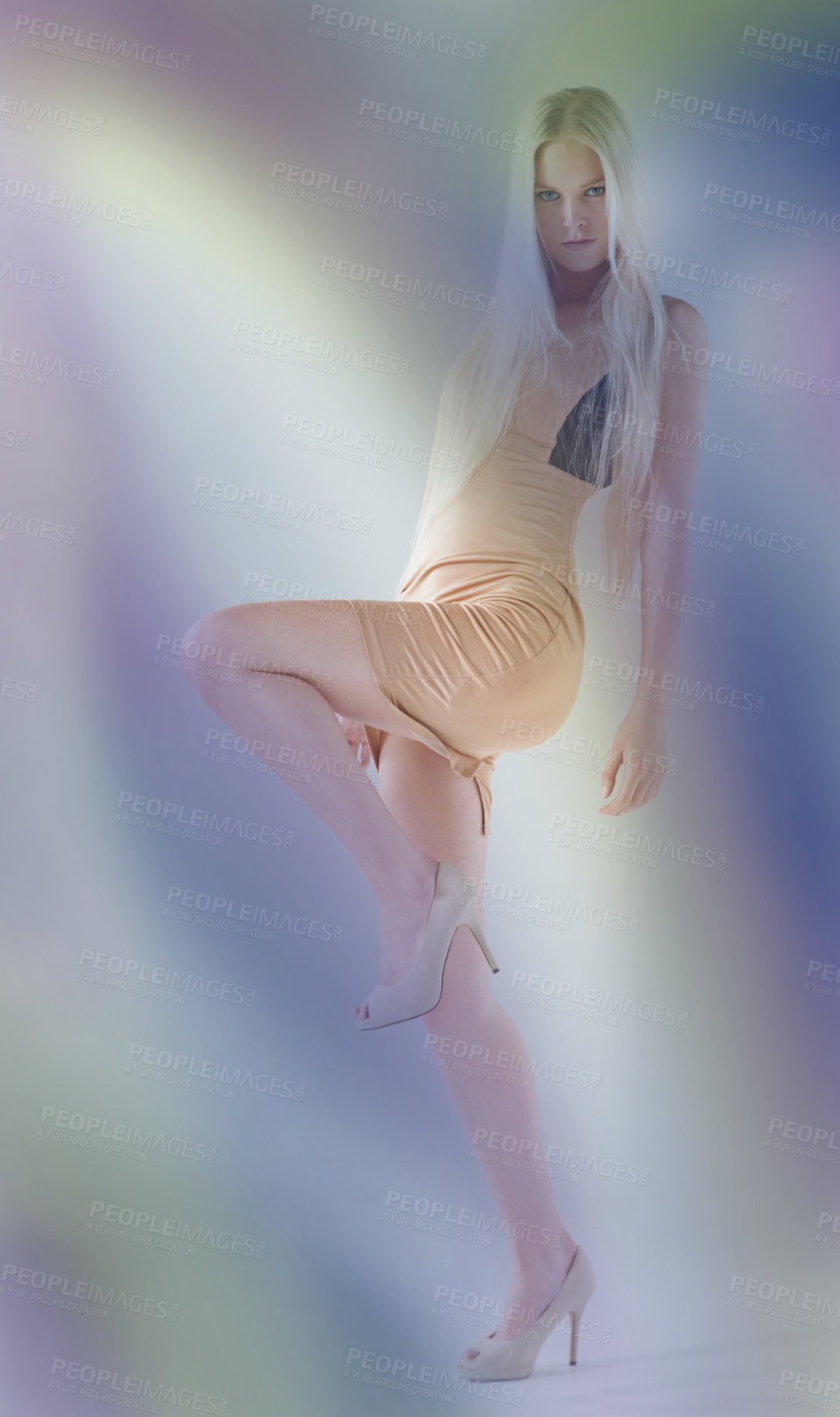 Buy stock photo Portrait of an attractive young female wearing a dress and lifting her leg with colours floating around her