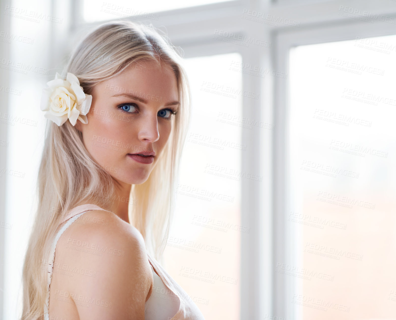 Buy stock photo Portrait of an attractive woman with a white rose in her hair while standing in her bedroom