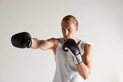 Buy stock photo A handsome young male boxer wearing a vest and throwing a punch