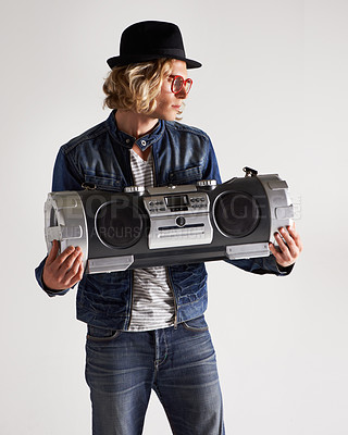 Buy stock photo Boombox, fashion and retro style of a man in studio with music, radio or audio sound and noise. Male model person on a white background with denim outfit, glasses and hipster hat to listen to song