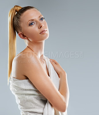 Buy stock photo Cropped shot of a beautiful young woman draped in linen against a gray background