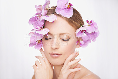 Buy stock photo Studio shot of a gorgeous young woman with pink orchids in her hair