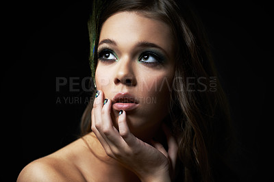 Buy stock photo Shot of a young woman with dramatic makeup looking away thoughtfully