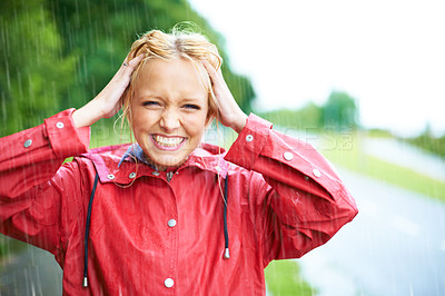 Buy stock photo Gorgeous young blonde woman wearing a red raincoat in the rain outdoors on a country road