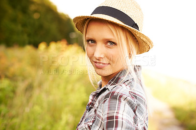 Buy stock photo Beautiful young woman in a field while wearing a straw fedora