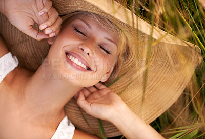 Buy stock photo Woman, hat and relax on grass with peace, happiness and freedom in summer. Outdoor, fashion and girl lying on lawn with a smile on face for holiday, vacation or free time in nature with carefree joy