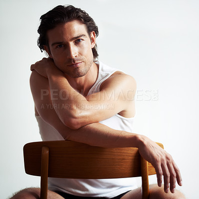 Buy stock photo Portriat of a handsome young man sitting on a chair