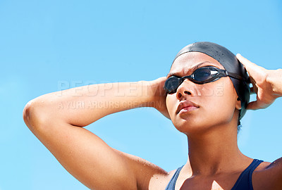 Buy stock photo Determined young female swimmer adjusting her swimming goggles