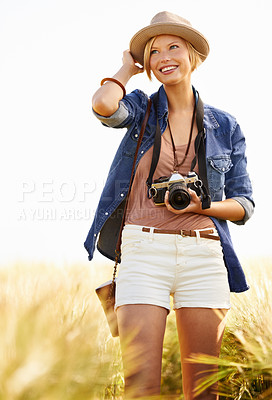 Buy stock photo Field, photographer and woman with a camera, adventure and thinking with ideas, nature and memory. Person, countryside and girl with photography, tourism and journey with sunshine, smile and travel