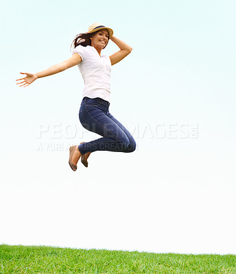 Buy stock photo Nature, happy and woman jumping on grass for positive, joyful and confident attitude by blue sky. Smile, portrait and young female person from Canada leap on green lawn at outdoor garden in summer.