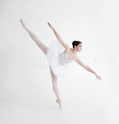 Buy stock photo Elegant young ballerina dancing en pointe against a white background in penche position